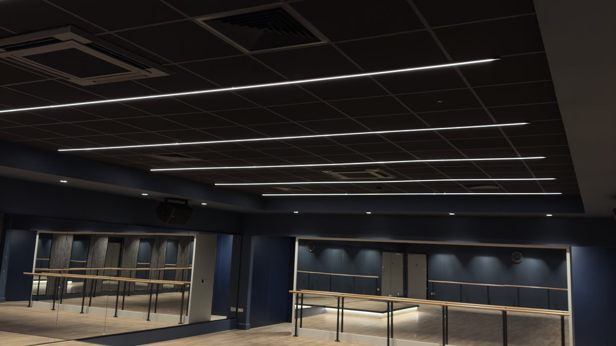 Black grid ceiling with recessed linear lighting to a studio at David Lloyd, St Neots